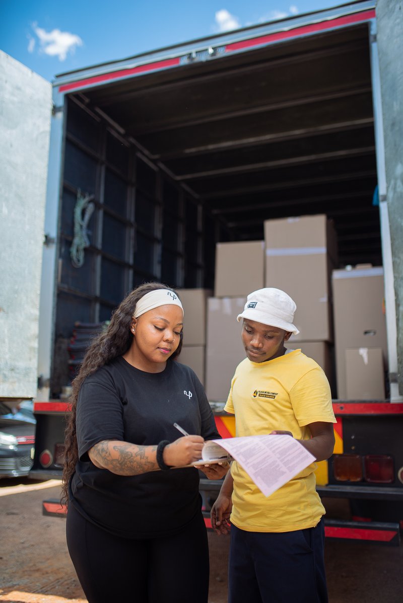 Staff reviewing paperwork by a moving truck